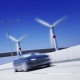 以风力涡轮机为背景的高速公路上绿色运输车辆超速的三维渲染概念（汽车和涡轮机上的运动模糊和背景中的自由度）
